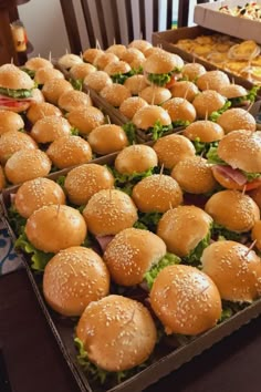 several trays filled with hamburgers sitting on top of a table