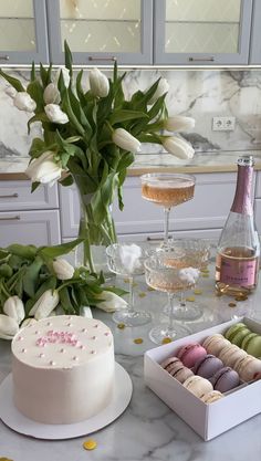 a white cake sitting on top of a table next to a vase filled with flowers