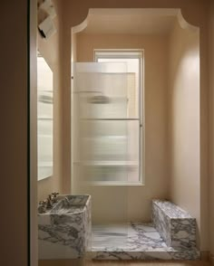 an empty bathroom with marble steps leading up to the window