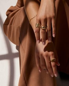 Smooth and futuristic, our 14k gold Dome Ring was created to make a statement while remaining compact enough to stack with other rings alike. Its shiny, polished surface offers a chunky presence and makes a statement solo but looks equally as prodigious when layered with a handful of rings. The Large Dome Ring has been hollowed out for ultra-lightness and measures 10mm at its widest, tapering to 3.5mm in the back for comfortable wear. Made to order. Please allow one week for production. Dome Ring Stack, Jewellery Editorial Shoot, Holiday Jewelry Campaign, Jewelry Model Poses, Fashion Jewelry Photography, Rings Styling, Gold Dome Ring, Jewellery Photography Inspiration, Jewelry Product Shots