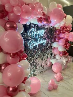 balloons and streamers are on the floor in front of a happy birthday sign