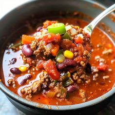 a spoon full of chili and ground beef soup