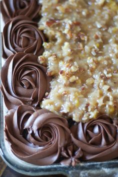 a close up of a cake in a pan with chocolate frosting and pecans