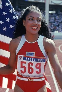 a woman in a red and white bathing suit holding an american flag