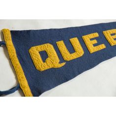 a blue and yellow pennant with the word queen on it