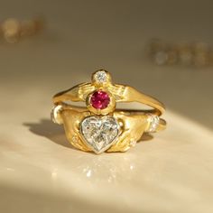 A ruby and diamond perched in a pair of tiny hands. Gold Heart Engagement Ring, Ruby And Diamond Ring Engagement, Vintage Heart Engagement Rings, Vintage Heart Ring, Heart Ring Gold, Sacred Heart Engagement Ring, Vintage 14k Gold Heart Ring, Statement Ring, Anthony Lent Rings