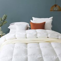 a bed with white comforter and pillows on it