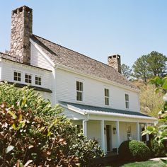 a large white house sitting on top of a lush green field