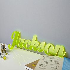 a neon green sign that says jackson on it next to some toys and an open book