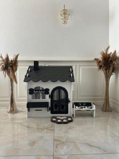 a white and black doll house with palm trees in the background, on marble flooring