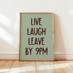 a green poster with the words live laugh leave by 9pm on it in front of a white wall