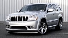 a silver jeep parked in front of a building