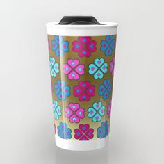 a coffee cup with colorful flower designs on the front and sides, sitting against a white background