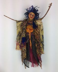 a cloth doll hanging on a white wall