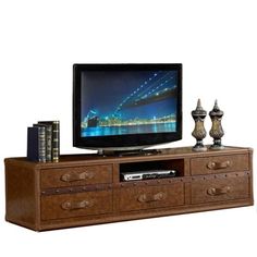 an entertainment center with a flat screen tv on it's stand and two vases next to it