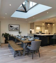 a dining room table with two benches and a skylight in the middle of it