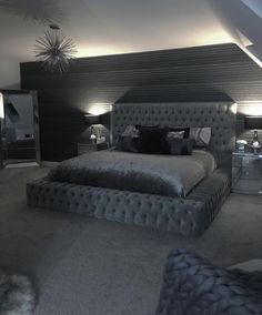 a large bed sitting in the middle of a bedroom next to two tables and lamps