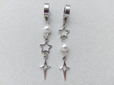 The earrings are decorated with white faux pearl beads. Silver-colored brass pendants in the shape of stars are attached to the earrings. These earrings are without ear piercing The earrings are fastened with stainless steel clips. Earring length - 7.0 cm (2.8 inches) Earrings  are packed in a gift box RECOMMENDATIONS FOR CARE: Do not wet, do not drop, and store in a dark box! - Remove jewelry before exercising, swimming, showering and sleeping. - Avoid contact with moisture such as make-up, moi Alt Jewelry, No Piercing Earrings, Star Clips, Earrings No Piercing, Brass Pendants, Piercing Earrings, Y2k Goth, Ear Piercing, Grunge Y2k