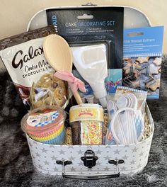 a basket filled with lots of food and baking supplies on top of a black rug