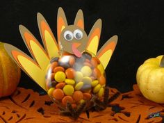 a turkey made out of candy sitting on top of a table next to pumpkins