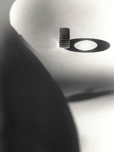 a black and white photo of a toothbrush in a sink with its reflection on the wall