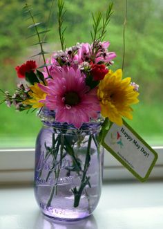 a vase filled with flowers sitting on top of a window sill next to a sign