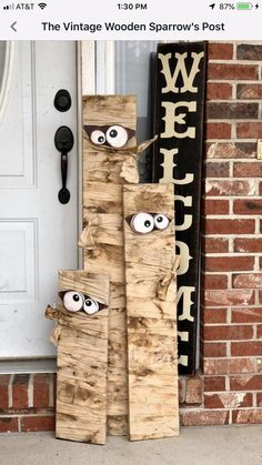 some wood sticks with eyes on them sitting in front of a door