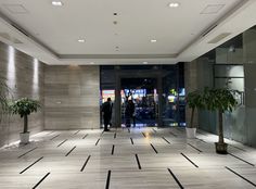 two people are standing in an empty lobby