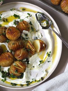 a white plate topped with potatoes covered in cream