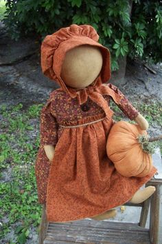 an old fashioned doll sitting on a wooden chair