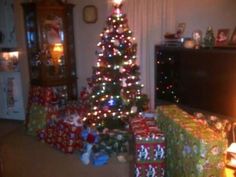 a christmas tree with presents in front of it