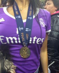 a woman wearing a purple shirt and medal around her neck