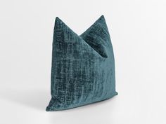 a dark green pillow with two pillows on the front and one in the back, both facing each other