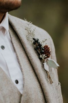 a man wearing a suit and tie with a boutonniere on his lapel