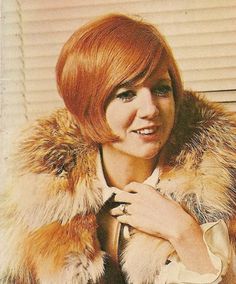 a woman with red hair wearing a fur coat