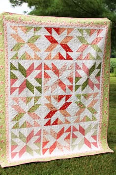 a large quilt is hanging on the grass