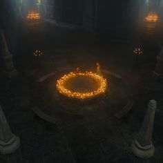 a person sitting on a bench in the middle of a circle with candles around it