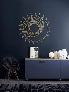 a black and gold room with a sun wall decal on the wall, sideboard