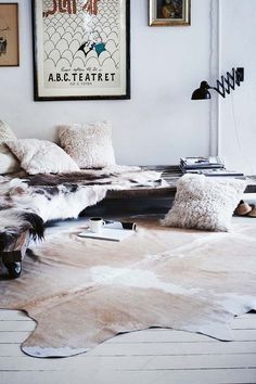 a living room filled with lots of furniture and pictures on the wall above it's headboard