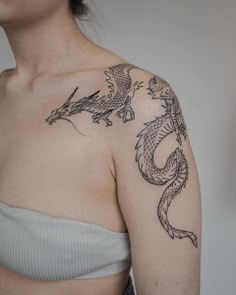 a woman with a dragon tattoo on her left shoulder and right arm behind her back