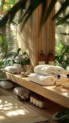 towels and soaps are arranged on a wooden shelf in a spa room with plants