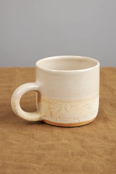 a white cup sitting on top of a wooden table