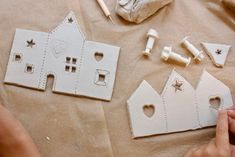 someone is making some paper houses out of clay