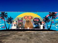 a large mural with dogs wearing sunglasses and palm trees