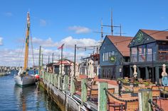 boats are docked at the dock in front of some buildings and other things on the water