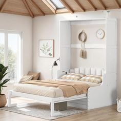 a white bed sitting under a wooden ceiling next to a window and potted plant