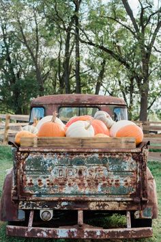 an old truck with pumpkins in the back