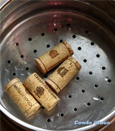 three wine corks sitting in a metal bowl