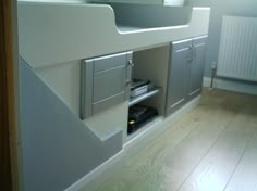 a white sink sitting under a window next to a wooden floor