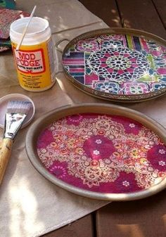 there are two trays with different designs on them and one has a paintbrush next to it